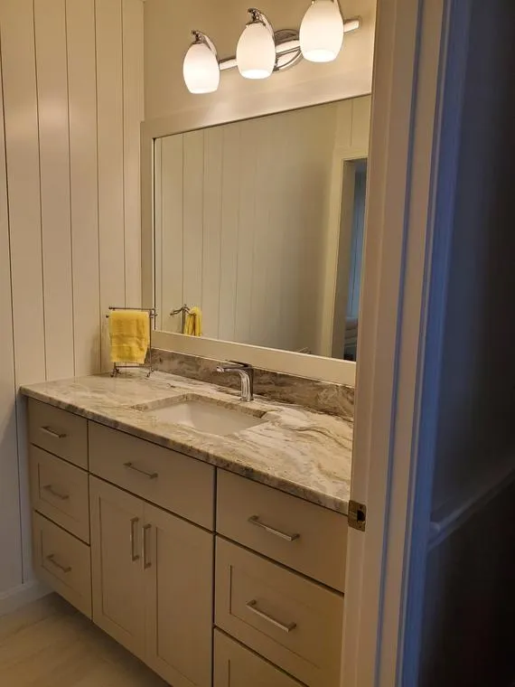 Bathroom vanity with stone counter and mirror
