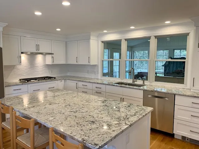 Kitchen with granite island and white cabinets